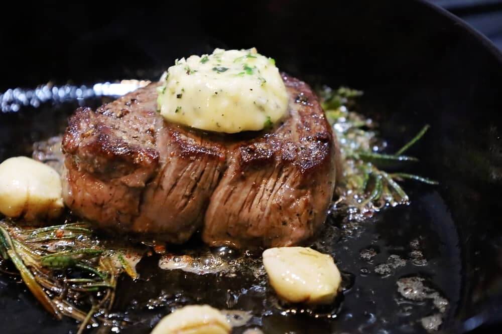 pan seared filet mignon with herbs in cast iron skillet