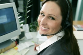 Person wearing a headset in an office setting with a computer monitor in the background
