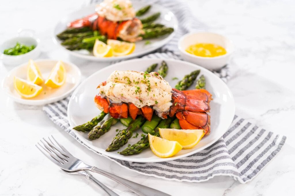 steamed lobster tails served with lemon wedges and asparagus