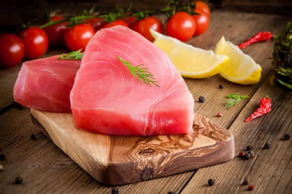 Raw tuna fillet steaks with dill, lemon and cherry tomatoes