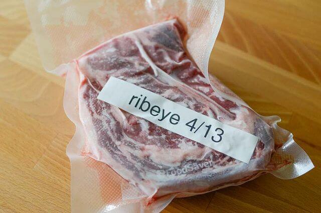 first step of how to cook wagyu beef starts with thawing the meat. Here is a piece of meat vacuum sealed and marked as ribeye and a date it was frozen.