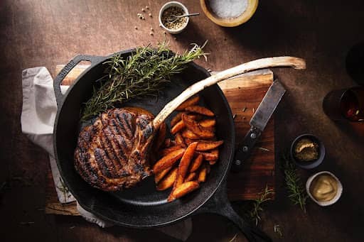 cooked tomahawk steak in cast iron skillet