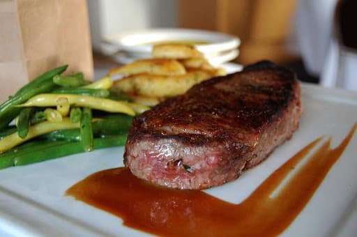 ribeye steak served on plate with vegetables