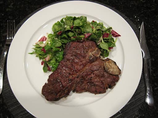 cooked porterhouse steak served with salad