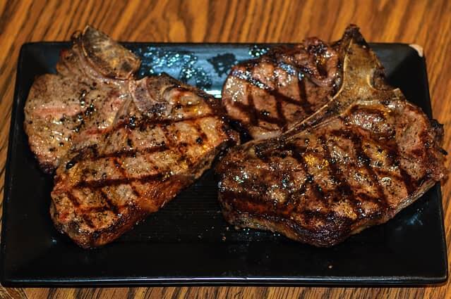 marinated porterhouse steak cooking and served on platter