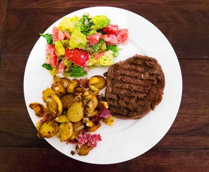ribeye steak with roasted potatoes and side salad