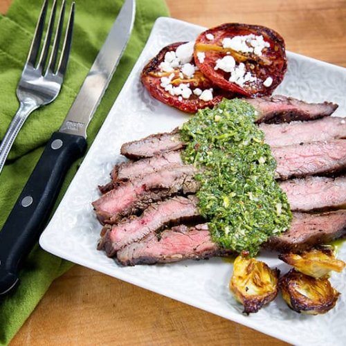 flank steak with chimichurri sauce served with tomatoes