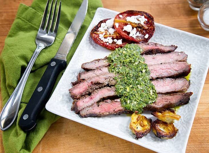 flank steak with chimichurri sauce served with tomatoes