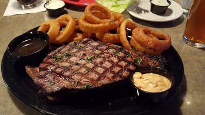 prime rib with onion rings and dipping sauces