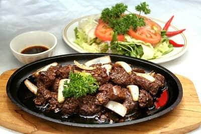 cooked cube steak ready to eat served with side salad