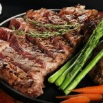 tri tip and ribeye steak served with asparagus and carrots