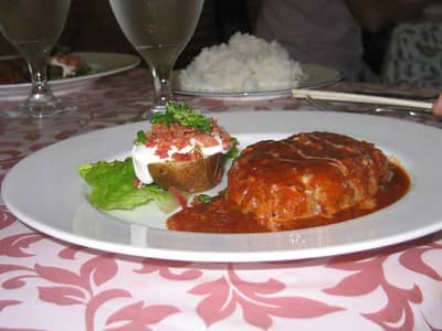 hamburger steak with sauce and served with loaded potatoes