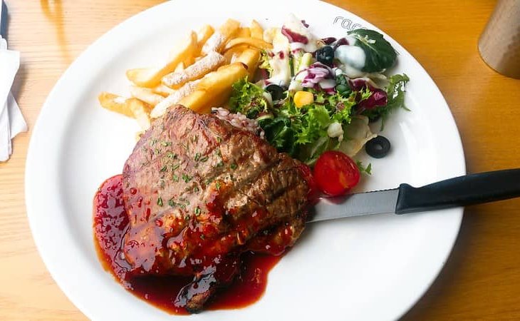 cooked bbq pork steak with salad and french fries