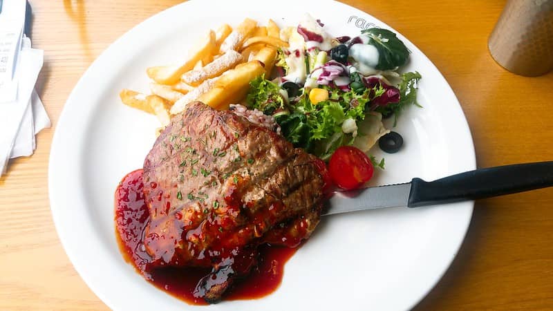 cooked bbq pork steak with salad and french fries