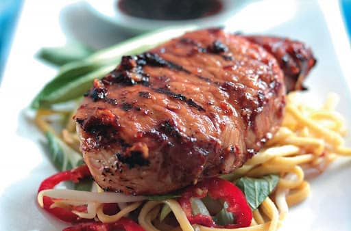 teriyaki pork steaks with soy sauce on vegetables