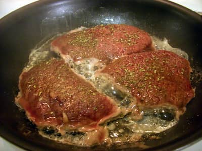 cooking cubed steaks on the stove in a pan