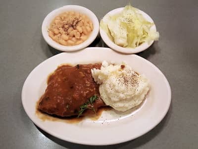 swiss steak served with mashed potatoes