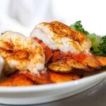 baked lobster tails served on platter with butter and broccoli